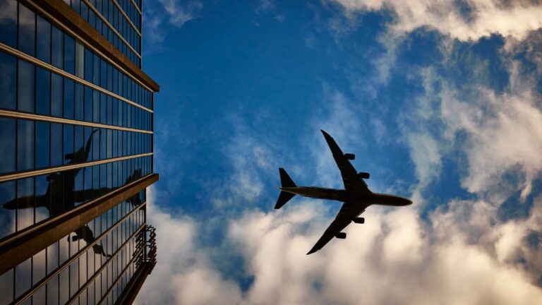 Fly fra Norwegian Air Shuttle flyver gennem skyer på himlen, der symboliserer selskabets økonomiske nedtur og penny stock