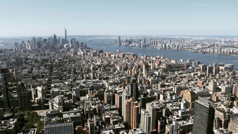 Bybillede af en storby i USA med skyskrabere og store bygninger, symboliserer Realty Income Corporations ejendomsmæssige investeringer