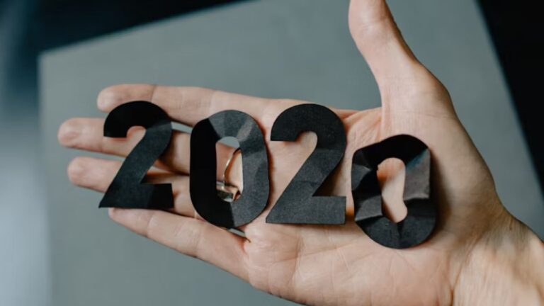 Flad hånd holder delvist sammenkrøllede tal, som symboliserer aktieåret 2020 og en refleksion over året der gik