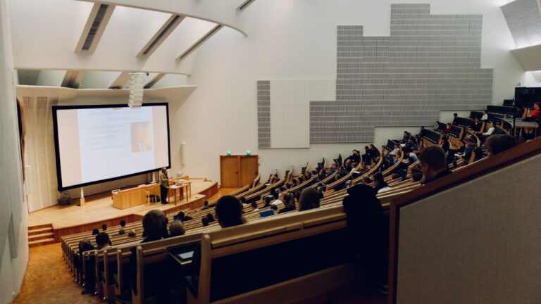 Studerende sidder i et stort auditorium, mens en underviser holder et oplæg, hvilket symboliserer en succesfuld studiestart